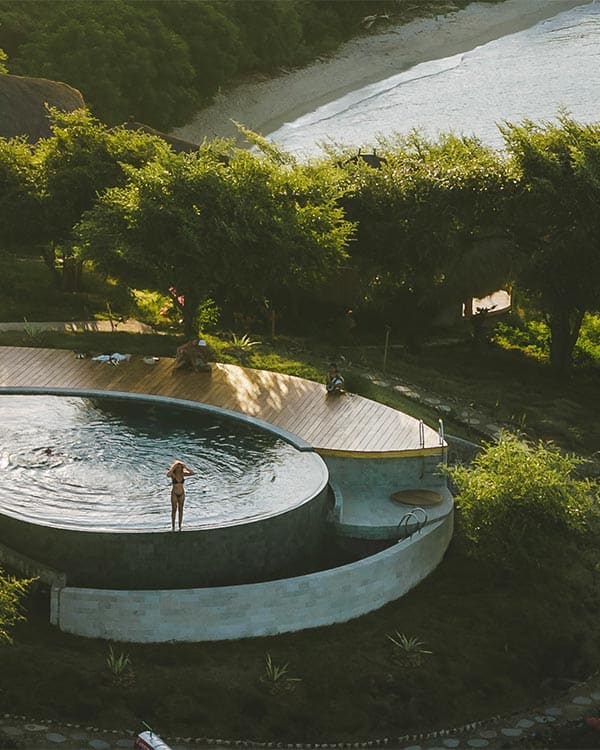 Ocean Mantra Village eco retreat on a clifftop above a triple-beach bay with uninterrupted Flores Sea views in East Sumbawa, Indonesia